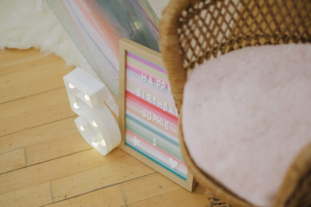 Styled corner with wicker chair, marquee light and sign