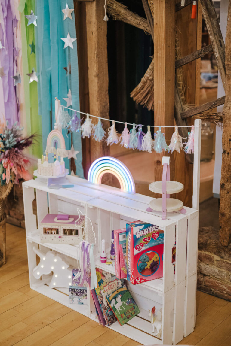 Crate display cart styled with a rainbow lamp and party props