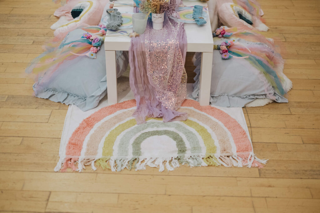 Low luxe picnic table styled on a rainbow rug with plush cushions